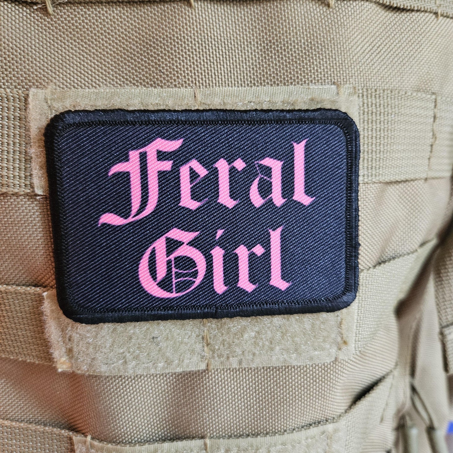 Pink on black "feral girl" girls and boys meme 2"x3" morale patch with hook and loop backing