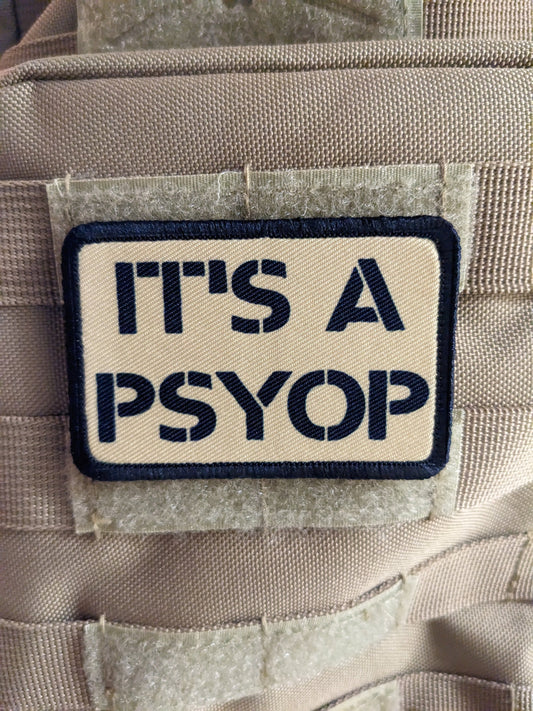 It's a Psyop conspiracy joke tan 2"x3" morale patch with hook and loop backing