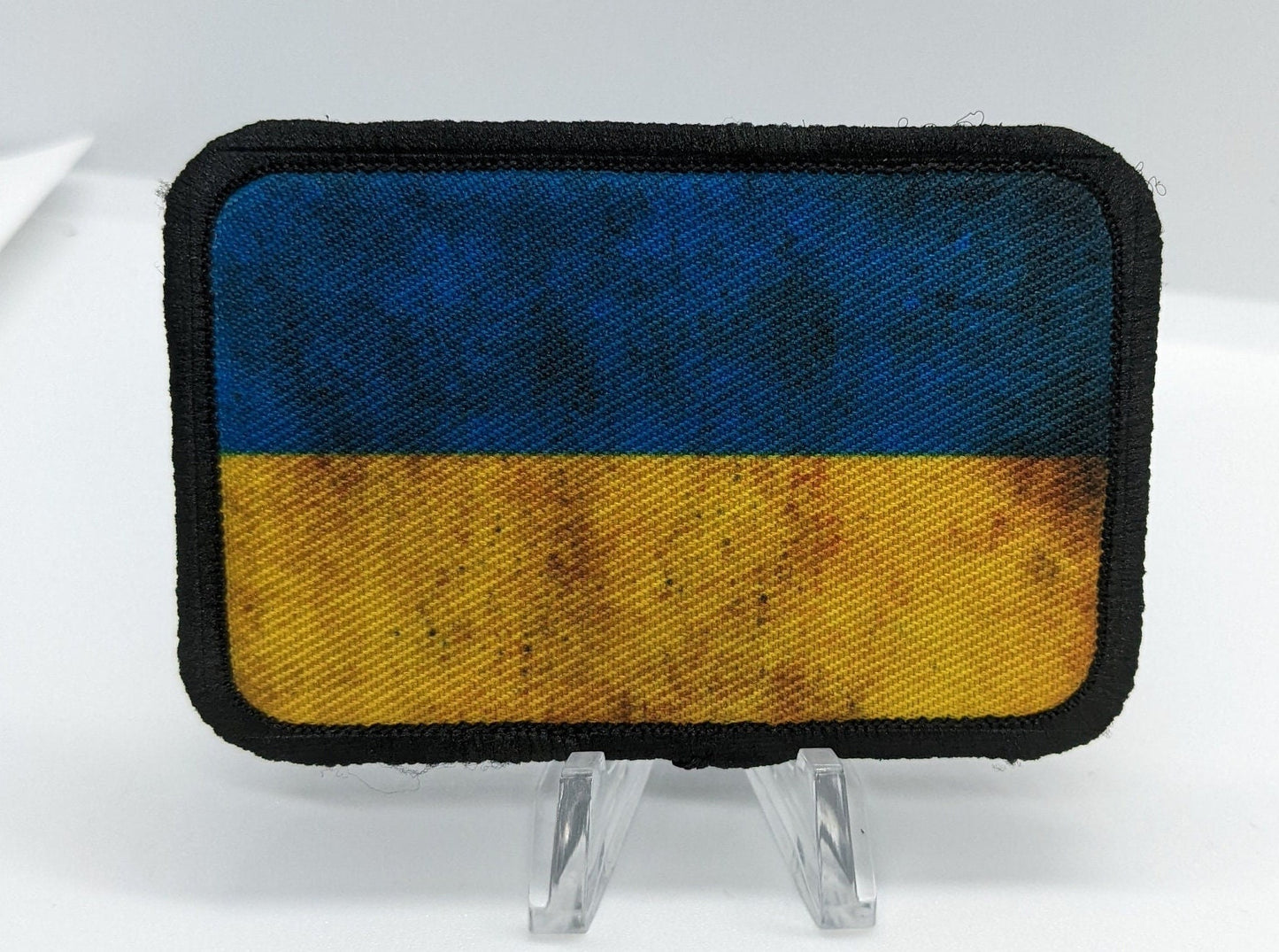 distressed Ukraine Flag stand with Ukraine 2"x3" morale patch with hook and loop backing