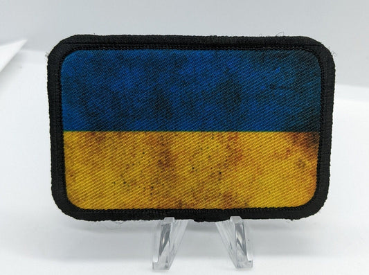 distressed Ukraine Flag stand with Ukraine 2"x3" morale patch with hook and loop backing