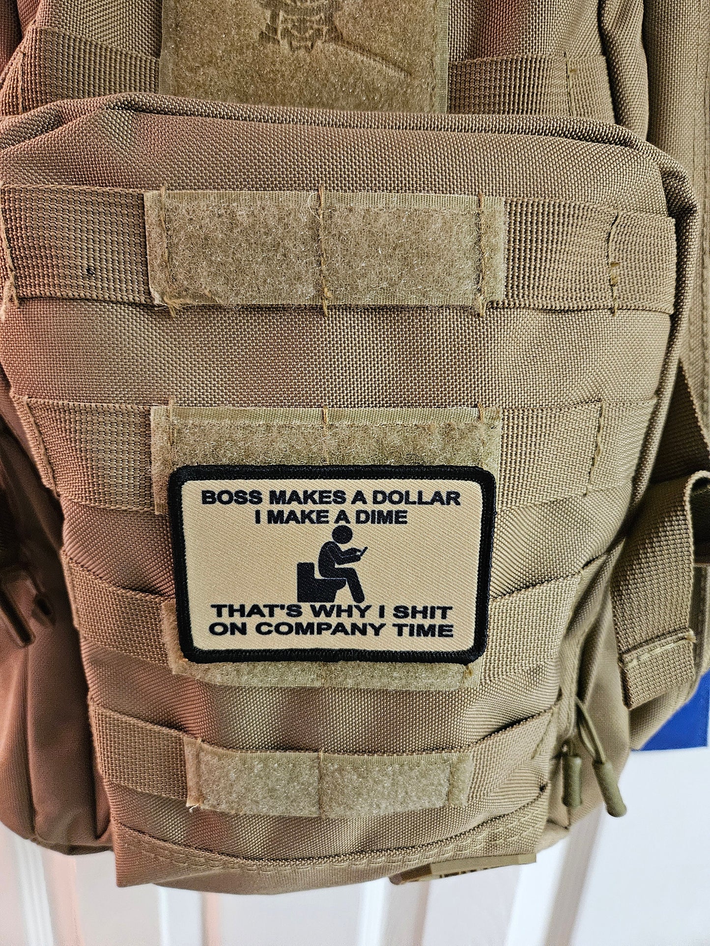 Boss makes a dollar I make a dime that's why I shit on company time 2"x3" morale patch with hook and loop backing tan