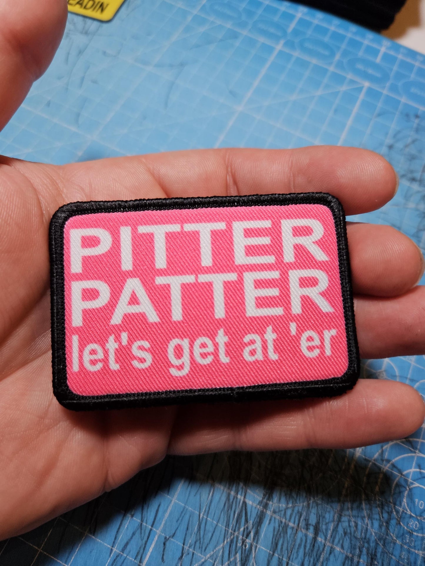 pink and white Pitter patter let's get at 'er meme 2"x3" removable morale patch with hook and loop backing