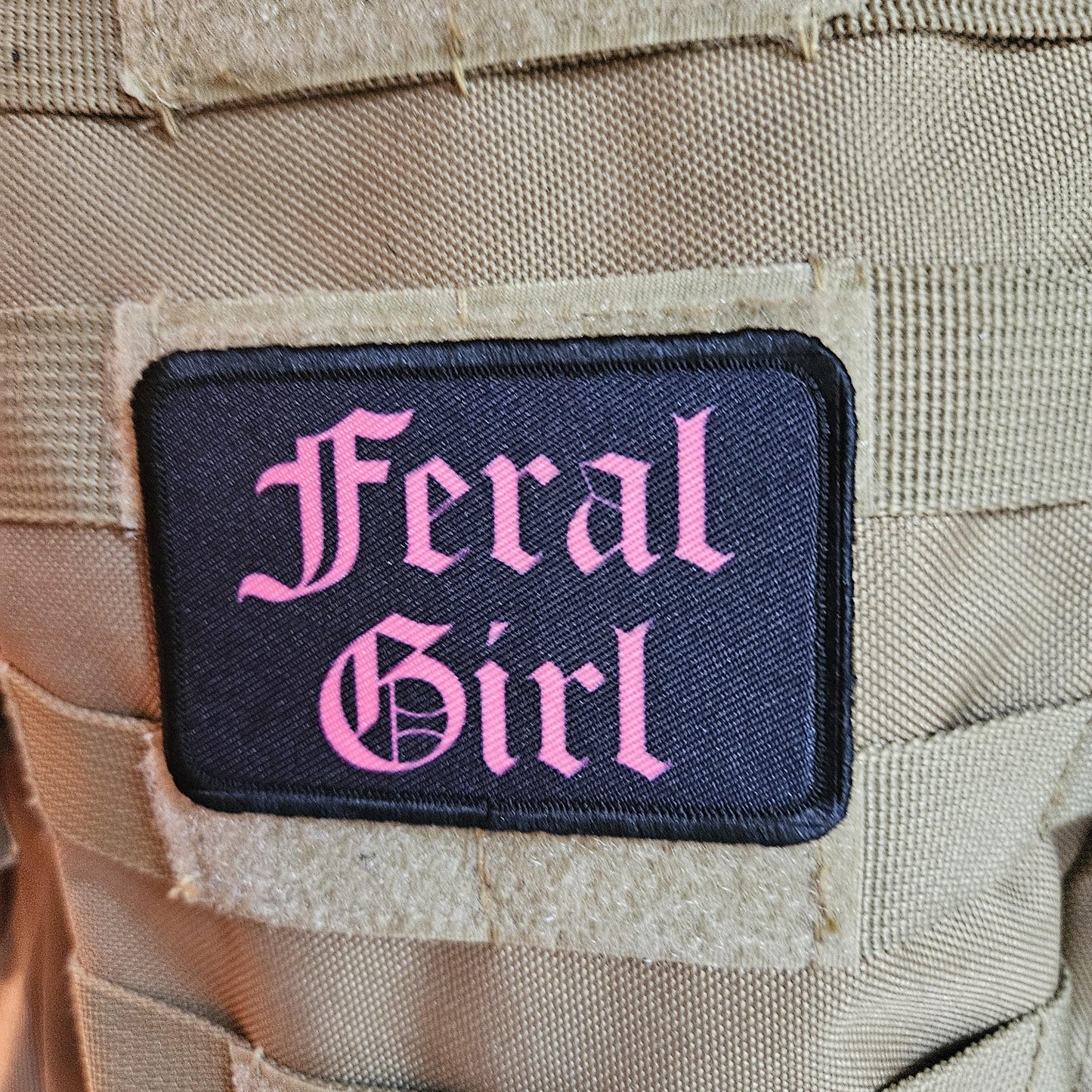 Pink on black "feral girl" girls and boys meme 2"x3" morale patch with hook and loop backing