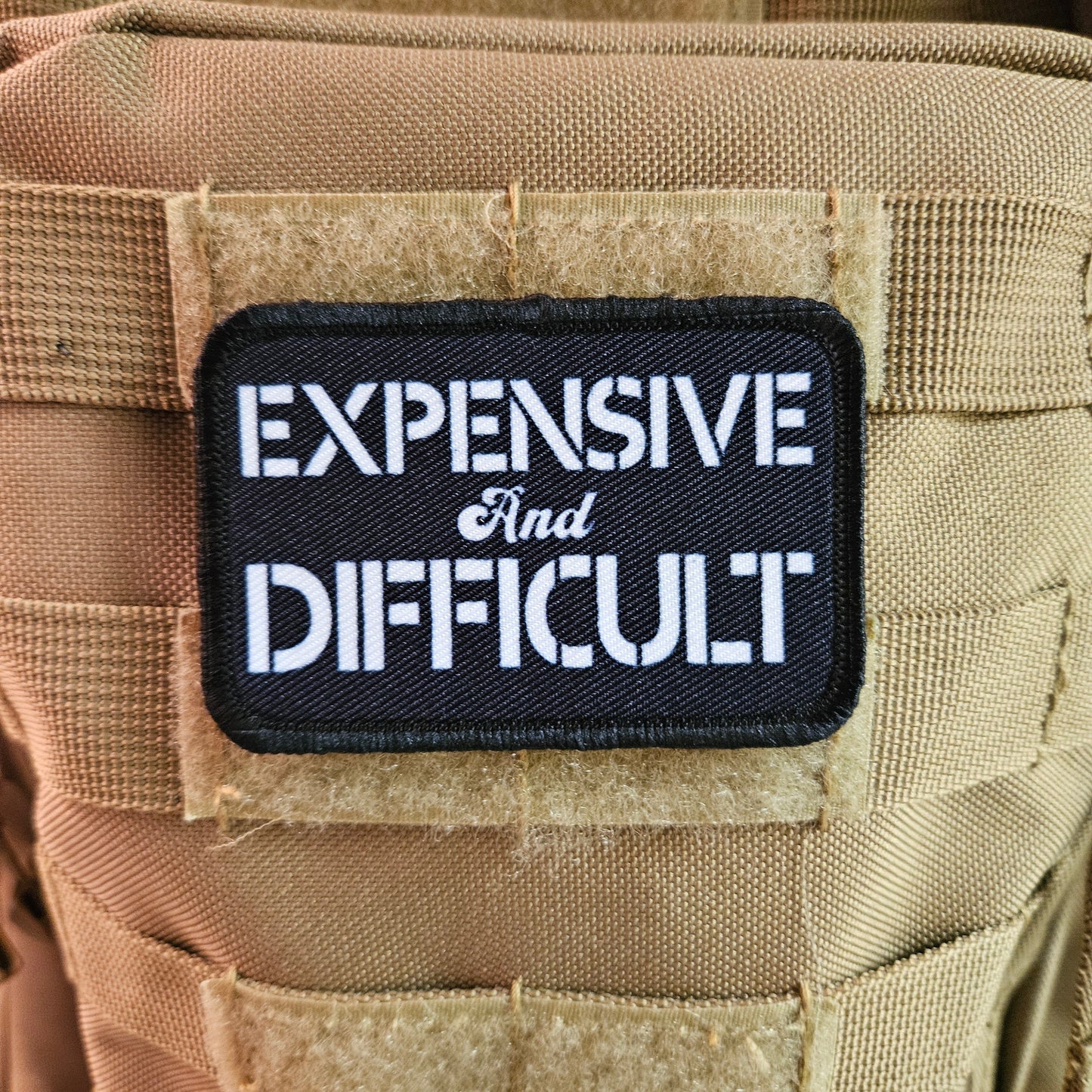 Expensive  and difficult meme black 2"x3" removable morale patch with hook and loop backing