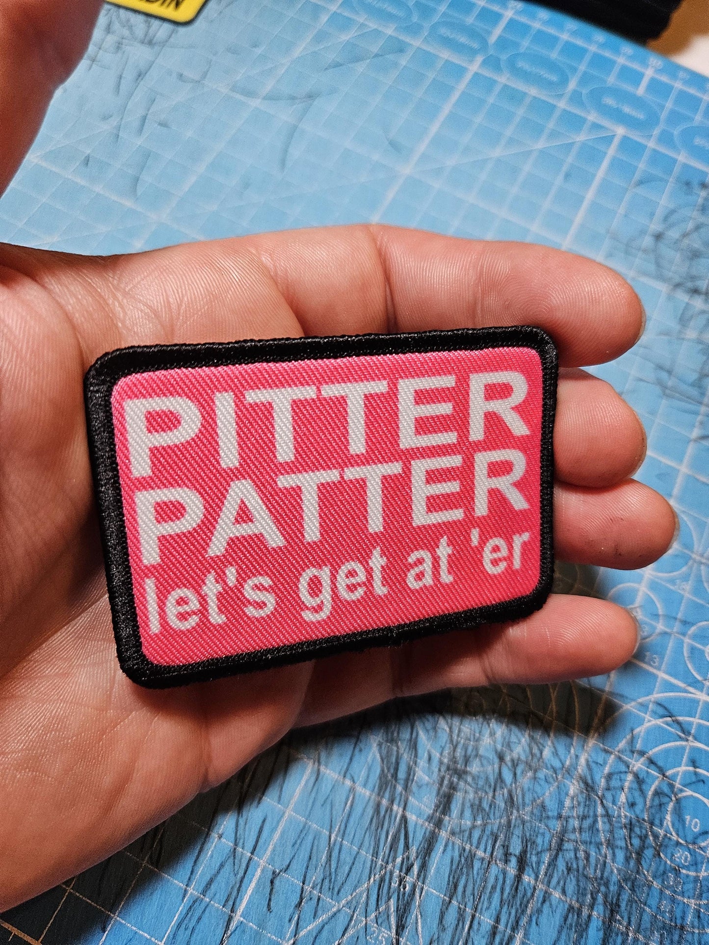 pink and white Pitter patter let's get at 'er meme 2"x3" removable morale patch with hook and loop backing