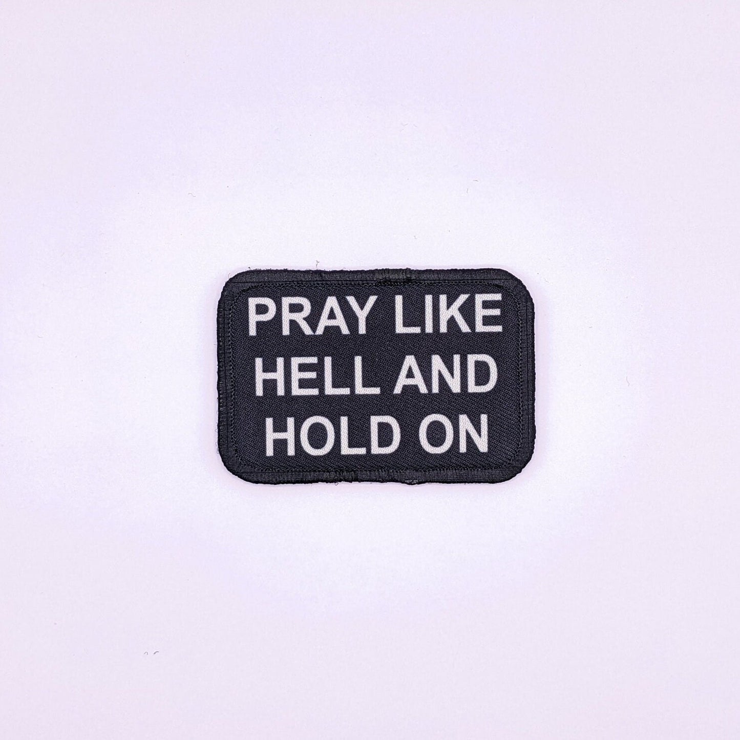 Pray Like HELL and HOLD on Yellowstone quote 2"x3" morale patch with hook and loop backing green background
