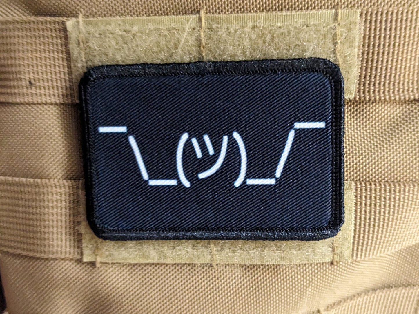 Text idk guy shrugging shoulders black background meme 2"x3" morale patch with hook and loop backing