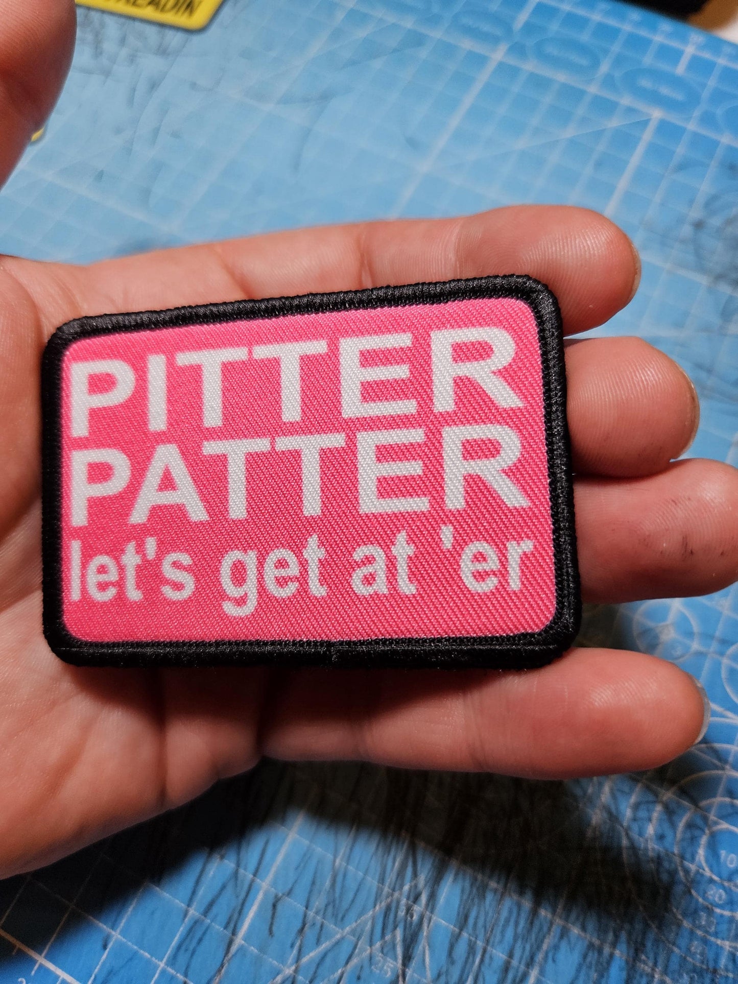 pink and white Pitter patter let's get at 'er meme 2"x3" removable morale patch with hook and loop backing